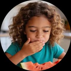 A child eating watermelon, a hand over the mouth